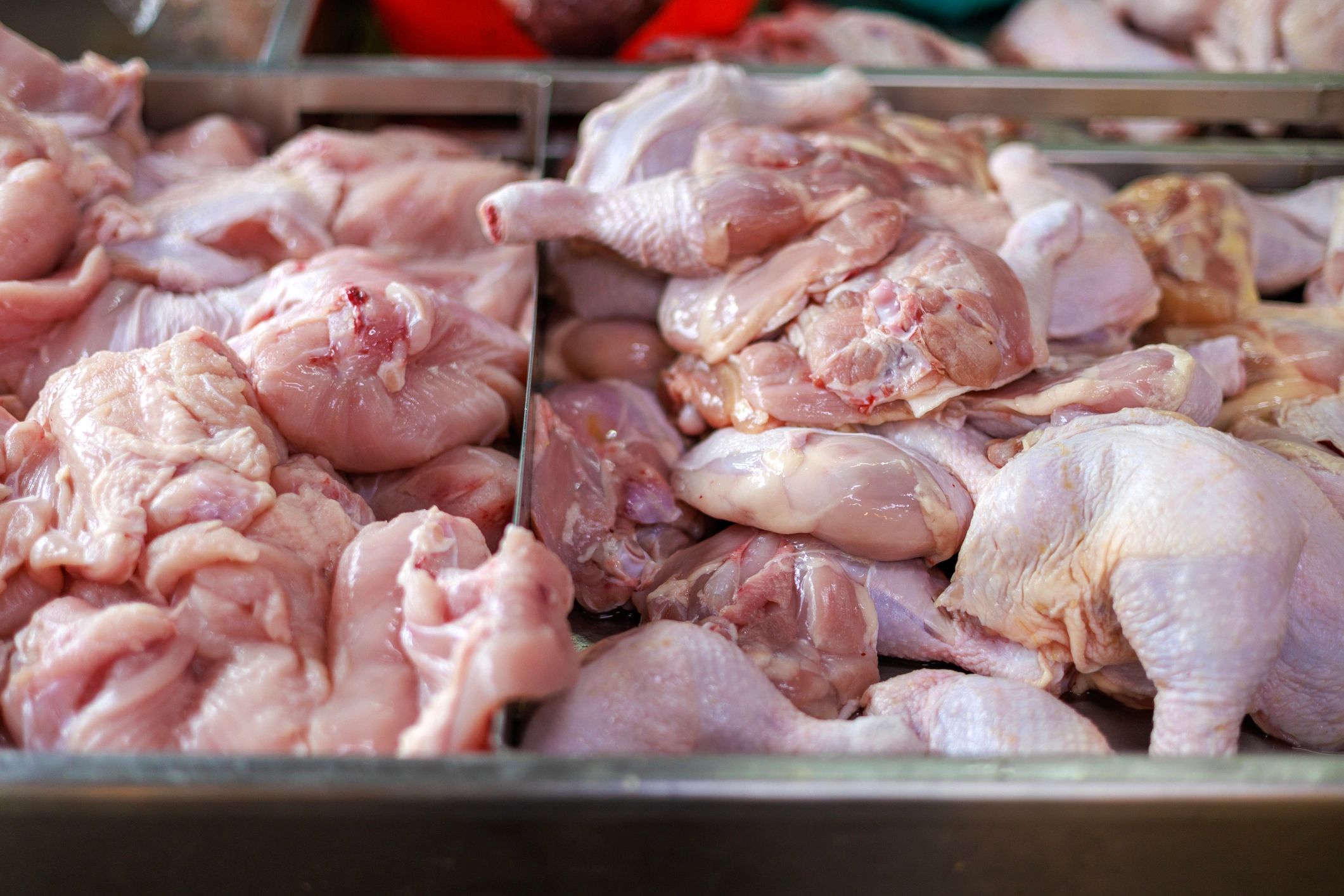 Fresh raw chicken parts displayed at a market stall
